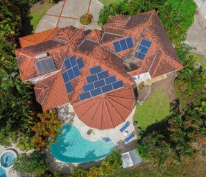 A house with a swimming pool, solar panels, and a red-tiled roof. - Spacious 5-bedroom house in soothing Bridgetown with AC (Bridgetown)
