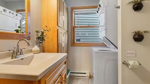 A compact kitchen with a sink, cabinets, a window, and a built-in washer and dryer. - Lakefront Cabin - Paddleboat, Paddleboards & Fishing Dock Included. Pet friendly (Lindstrom)