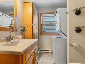 A compact kitchen with a sink, cabinets, a window, and a built-in washer and dryer. - Lakefront Cabin - Paddleboat, Paddleboards & Fishing Dock Included. Pet friendly (Lindstrom)