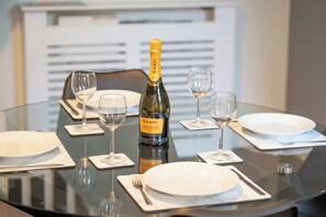 Ein gedeckter Tisch mit einem Canti Prosecco DOC, vier Weingläsern und Tellern mit Besteck.