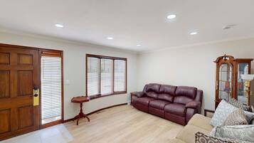 A living room with a leather sofa, a wooden cabinet, and a small table.