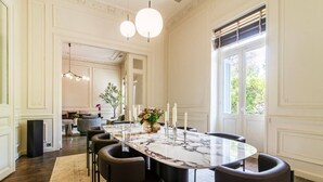 Un espace repas avec une table en marbre, des chaises noires et des bougies.