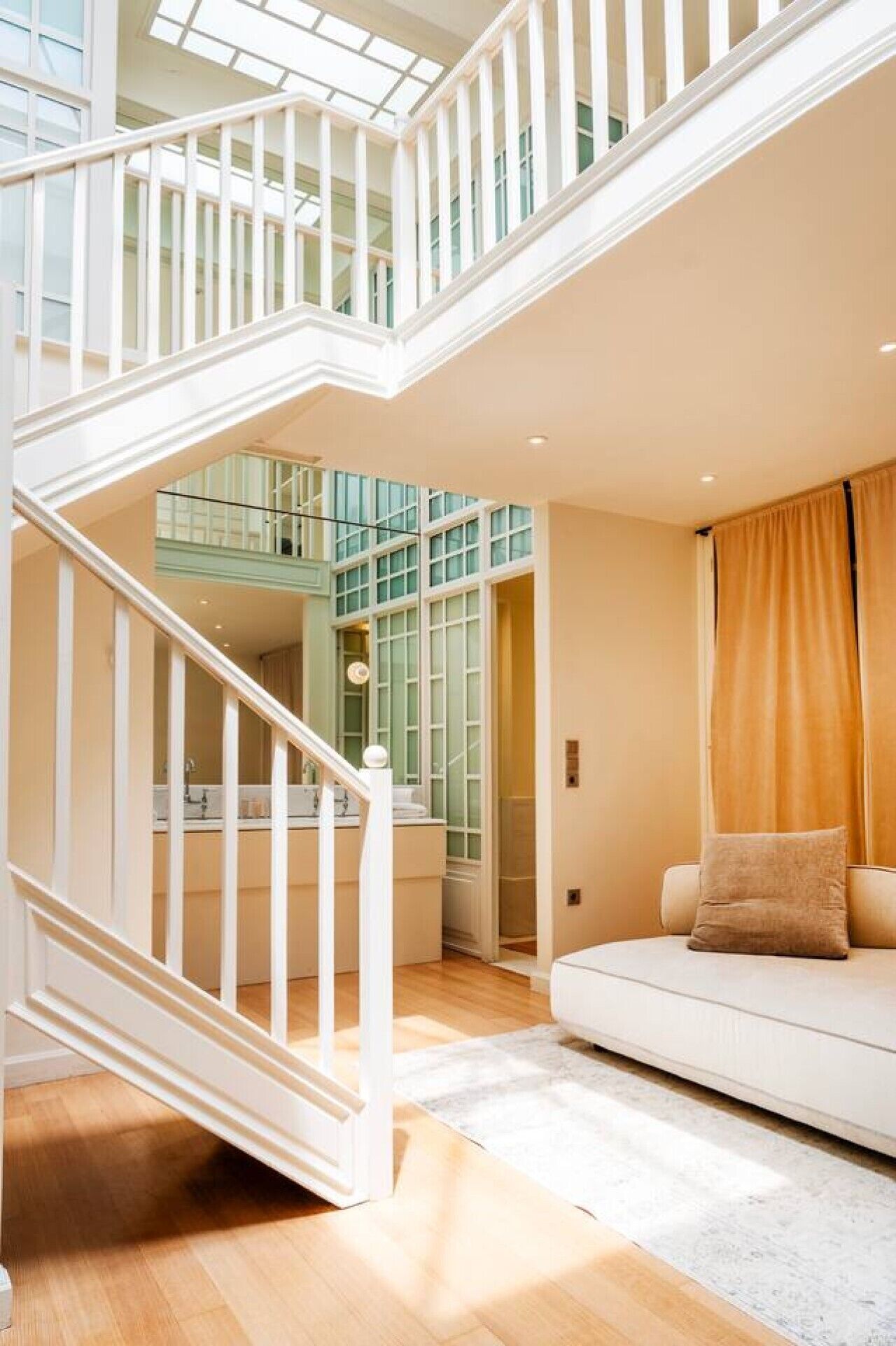 A multi-level interior with a staircase, a sofa, and a kitchen area.