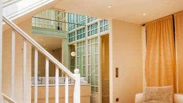 A multi-level interior with a staircase, a sofa, and a kitchen area.