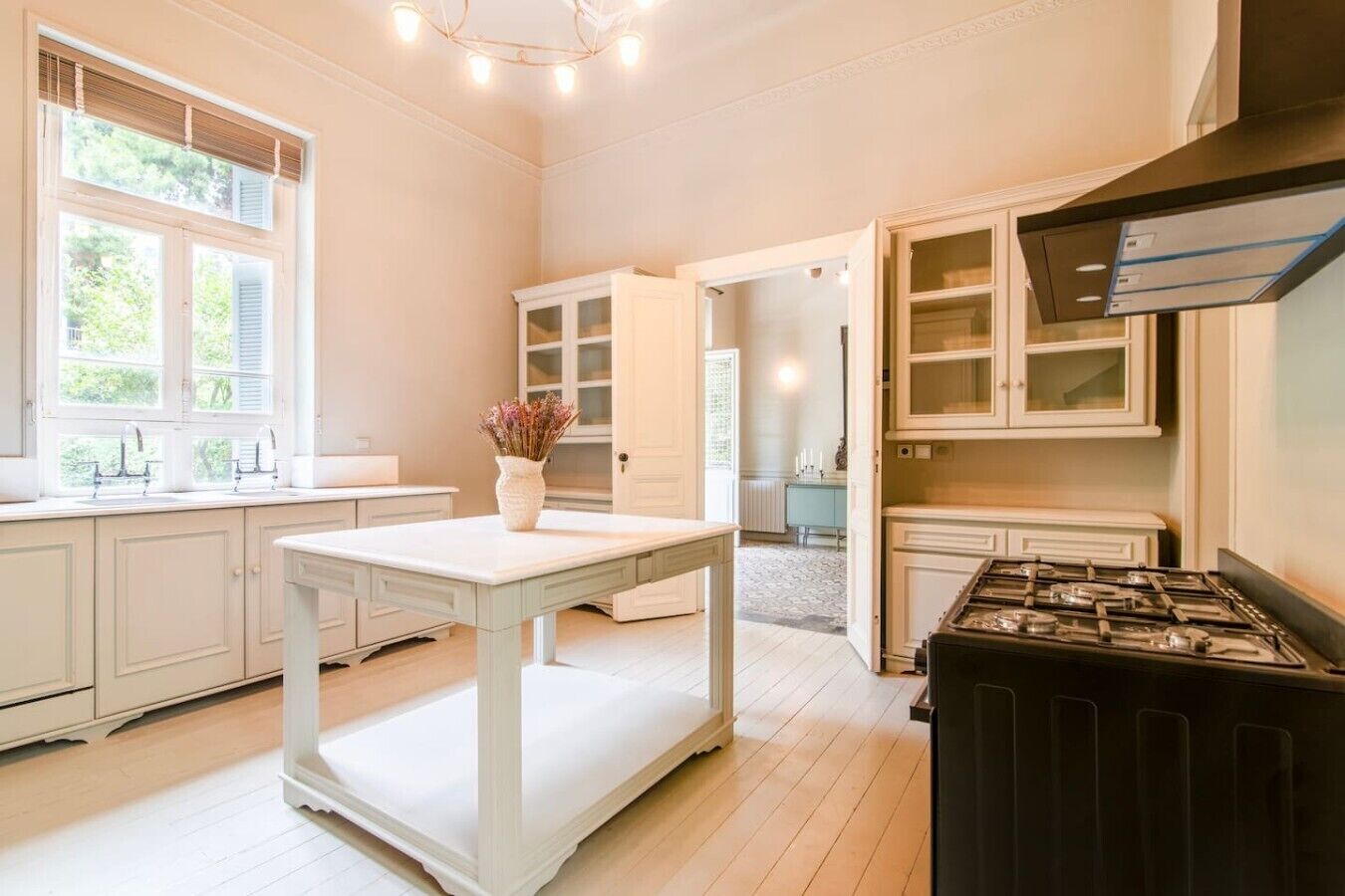 A kitchen with white cabinetry, a central island, and a gas stove.