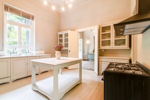 A kitchen with white cabinetry, a central island, and a gas stove.