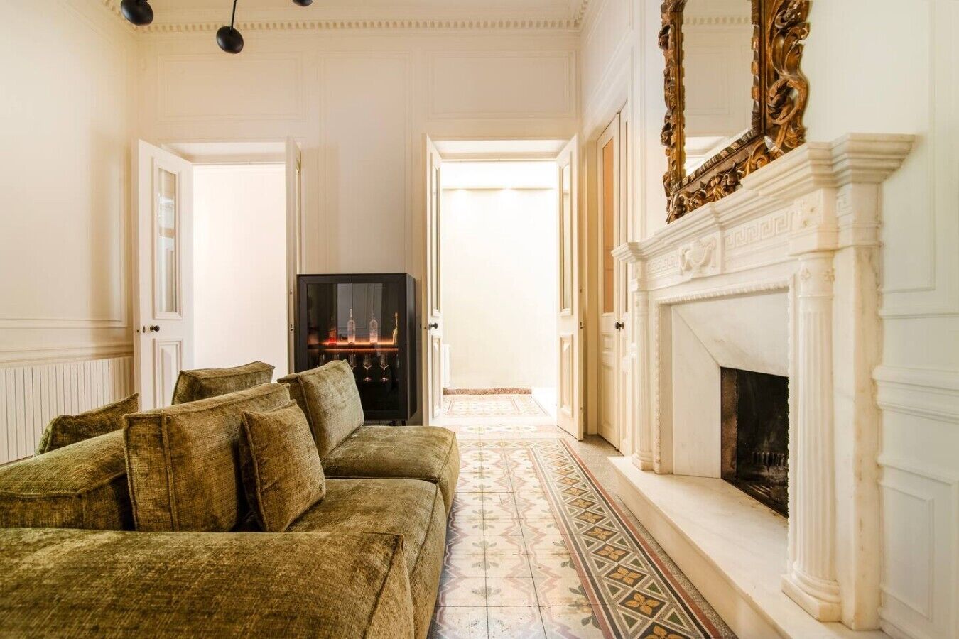 A room with a sofa, a fireplace, and a television.