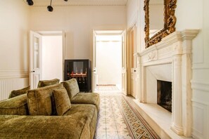 A room with a sofa, a fireplace, and a television.