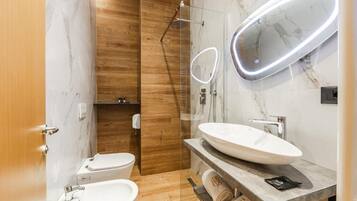 Une salle de bain moderne avec un meuble-lavabo en marbre, une cabine de douche en verre et des toilettes.