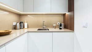 A modern kitchen with a sink, stainless steel kettle, and a coffee maker. - GuestReady-Charming Gaia Retreat with Balcony (Vila Nova de Gaia)