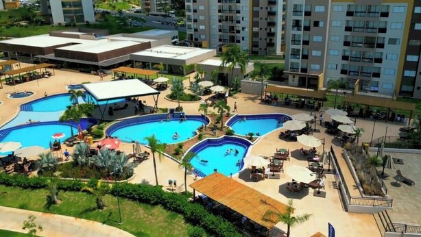Un resort con múltiples piscinas, zonas de estar al aire libre y un jardín ajardinado.