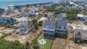 Un quartier résidentiel situé sur la côte, avec des maisons, une plage et une vue dégagée sur l’océan.
