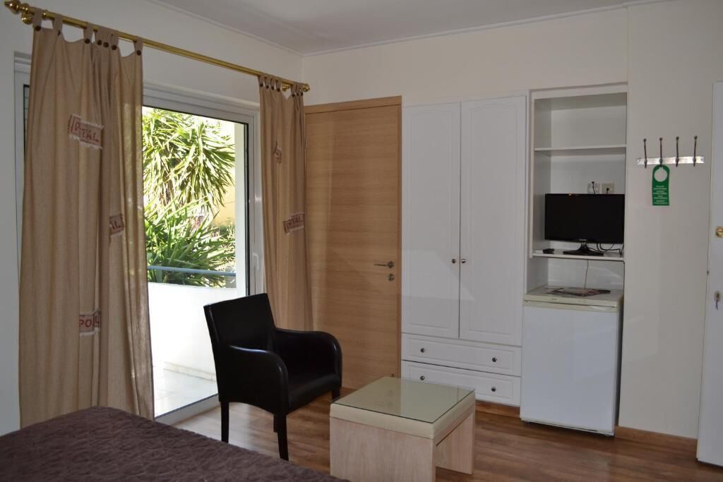 Une chambre comprenant un lit, un bureau, une chaise, une armoire et un téléviseur.