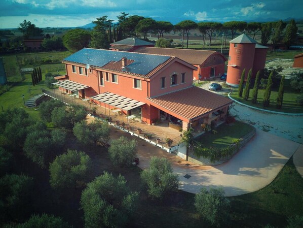 A large, red-roofed building with multiple levels, a covered patio area, and a tower structure. - Homerez - Spacious Villa with Pool in Segni (Segni)