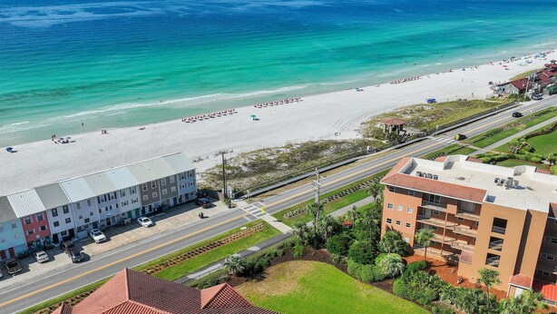 A coastal hotel with a beach view, multiple floors, and a parking area. - Ciboney 1010 (Miramar Beach)