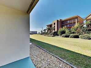 A building with a flat roof, a balcony, and a well-maintained lawn. - Ciboney 1010 (Miramar Beach)