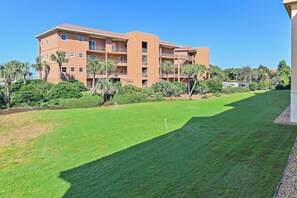 A multi-story building with balconies, surrounded by well-maintained lawns and palm trees. - Ciboney 1010 (Miramar Beach)