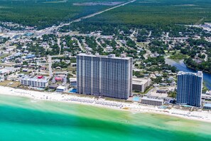 Eine Vogelperspektive einer Küstenstadt mit einem großen Hotel, einem Strand und einem Fluss.
