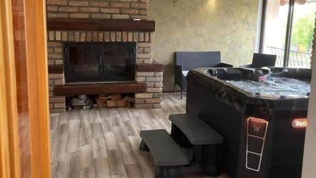 Cozinha moderna com lareira de tijolos, soalho de madeira e uma banheira de hidromassagem.