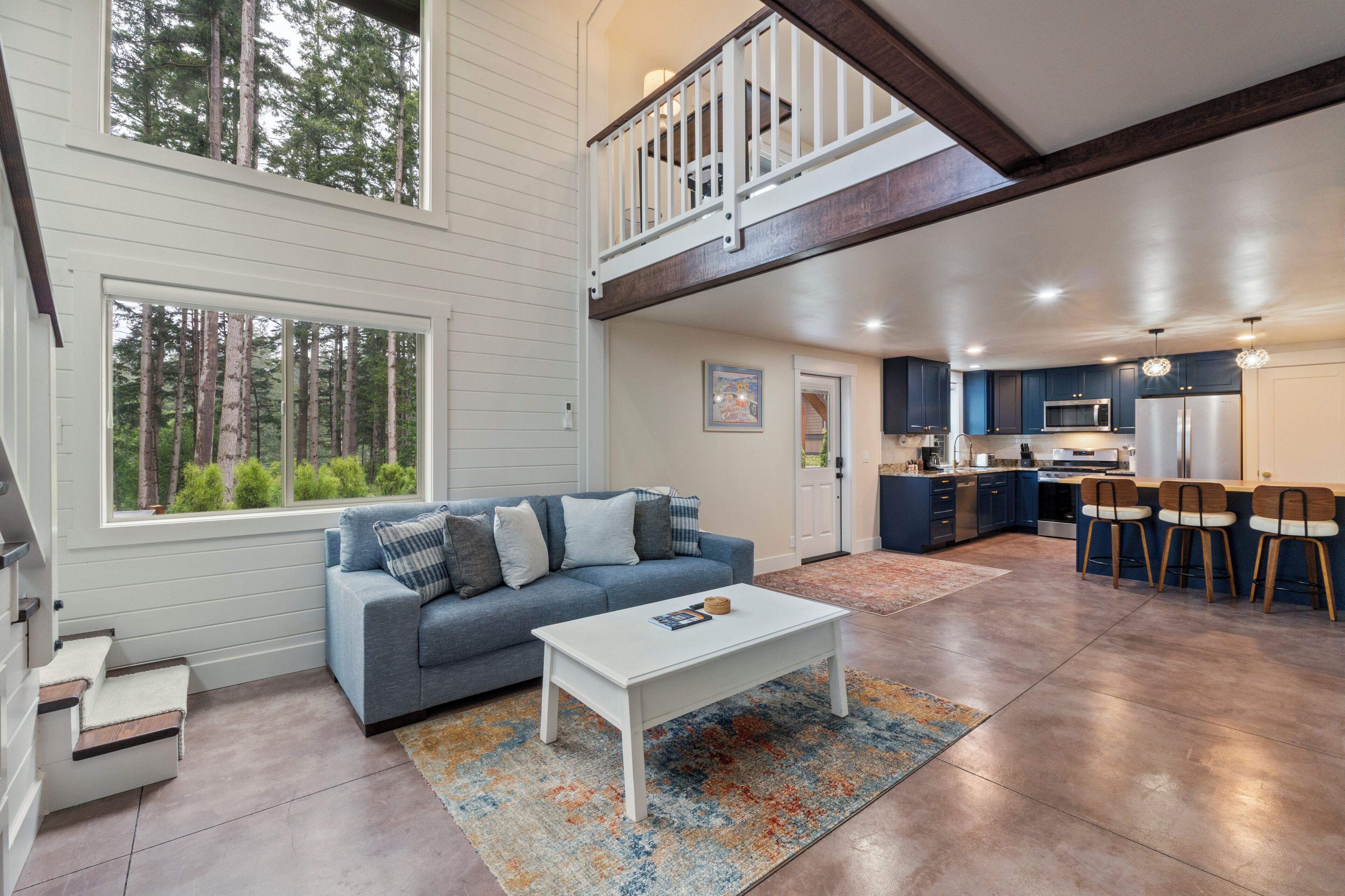 A spacious living area with a sofa, coffee table, and a view of the outdoors.