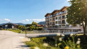 Un edificio a più piani con balconi, un ponte e una strada che vi conduce.