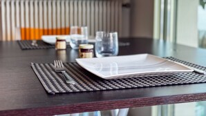 A dining table with a placemat, cutlery, a plate, and a glass. - Studio Terrasse Pointe Croisette A0b214 (Cannes)