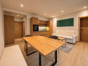 Un espacio moderno para vivir con una mesa de comedor de madera, un sofá y una zona de cocina.
