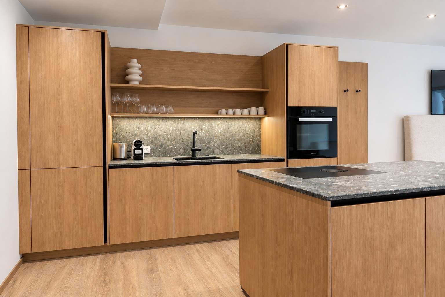 A modern kitchen with wooden cabinets, a built-in oven, and a granite countertop.