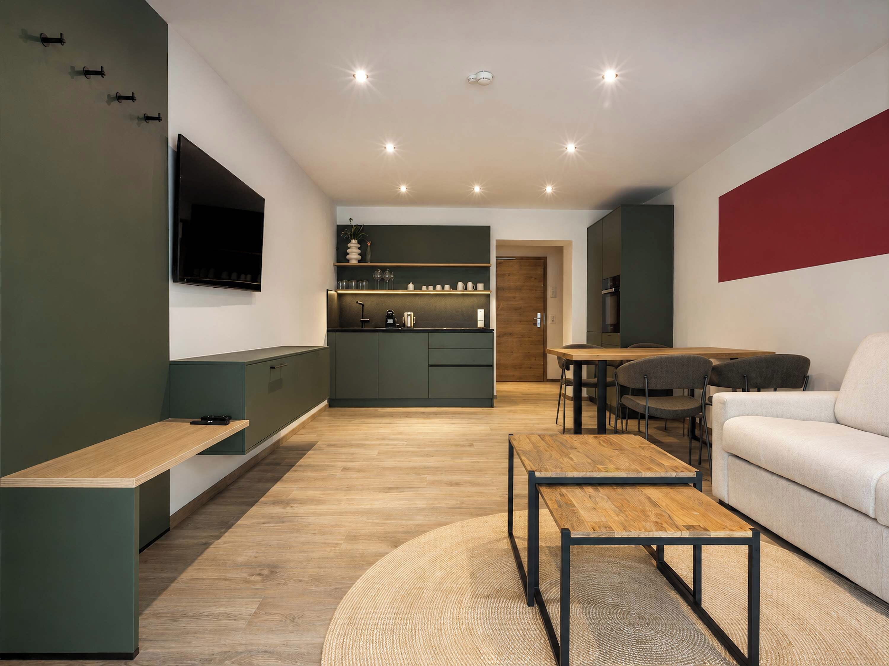 A modern living space with a kitchen, dining area, and seating.