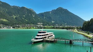 A boat docked at a pier with a mountainous backdrop. - BASE Achensee Freedom N°15 – Private mini gym (Achenkirch)
