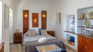 A bedroom with a bed, bedside tables, a nightstand, a dresser, and wall-mounted light fixtures. - Apartment with a terrace and a view of the garden (Albufeira)