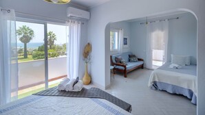 Una camera da letto con un letto, un divano, vista sull'esterno e un condizionatore d'aria.