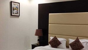 Habitación de hotel con una cama grande, una mesita de noche, una lámpara y un cuadro en la pared.