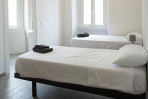 A bedroom with two beds, a window, and a door. - CAV2 [Loreto - Duomo] Apartment in Central Milan • (Milano)