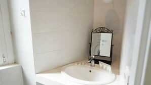 Un bany amb un vàter, un lavabo i un mirall.