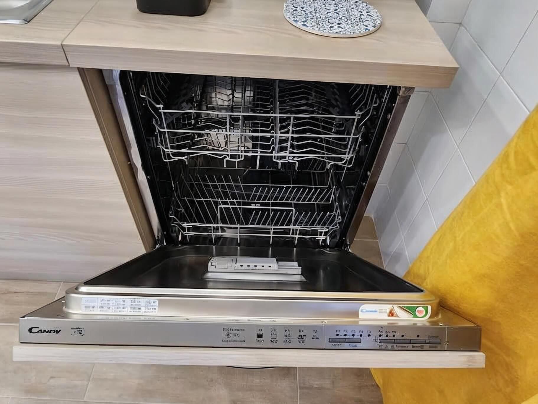 Een keuken met een vaatwasser, een magnetron en een spoelbak.