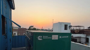 Una azotea con una unidad de generación de energía verde con la etiqueta 'Cummins Power Generation' y 'JAKSON' en un edificio.