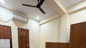 Un dormitorio con cama, armario, ventilador de techo y aire acondicionado.