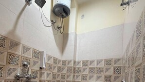 Un baño con inodoro, ducha y calentador de agua.