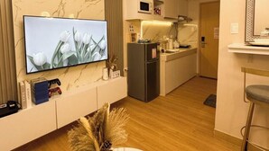 Eine moderne Küche mit eingebauter Mikrowelle, Kühlschrank und einer kleinen Kochinsel mit Spüle.