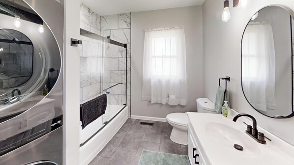 Une salle de bain moderne avec une baignoire, des toilettes et un lavabo.