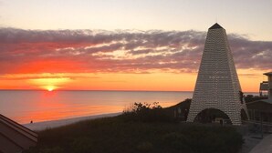 Korkea, moderni torni, jonka pää on terävä, ja josta avautuu näkymä rannalle auringonlaskun aikaan.