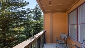A balcony with a metal railing, two metal chairs, and a window with blinds. - 1 Minute Walk to the Gondola/Shared Pool and Hot Tub/Private Patio (Keystone)