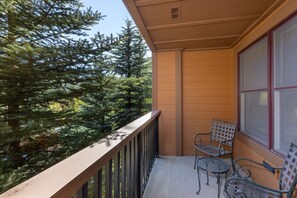 A balcony with a metal railing, two metal chairs, and a window with blinds. - 1 Minute Walk to the Gondola/Shared Pool and Hot Tub/Private Patio (Keystone)