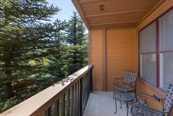 A balcony with a metal railing, two metal chairs, and a window with blinds. - 1 Minute Walk to the Gondola/Shared Pool and Hot Tub/Private Patio (Keystone)