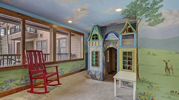A children's play area with a red rocking chair, a playhouse, and a mural of a deer and flowers. - 1 Minute Walk to the Gondola/Shared Pool and Hot Tub/Private Patio (Keystone)