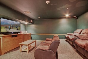 A home theater with a large TV, wooden entertainment unit, and leather recliner seating. - 1 Minute Walk to the Gondola/Shared Pool and Hot Tub/Private Patio (Keystone)