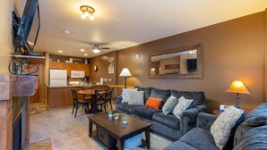 A living room with a sofa, coffee table, and a dining area with chairs and a microwave. - 1 Minute Walk to the Gondola/Shared Pool and Hot Tub/Private Patio (Keystone)
