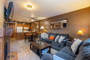 A living room with a sofa, coffee table, and a dining area with chairs and a microwave. - 1 Minute Walk to the Gondola/Shared Pool and Hot Tub/Private Patio (Keystone)