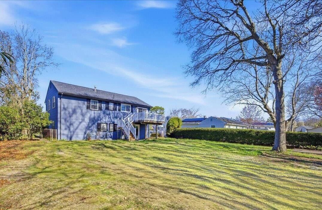 A two-story house with a front porch, a visible staircase, and a well-maintained lawn.